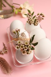 Festive composition with eggs and floral decor on pink background, above view. Happy Easter