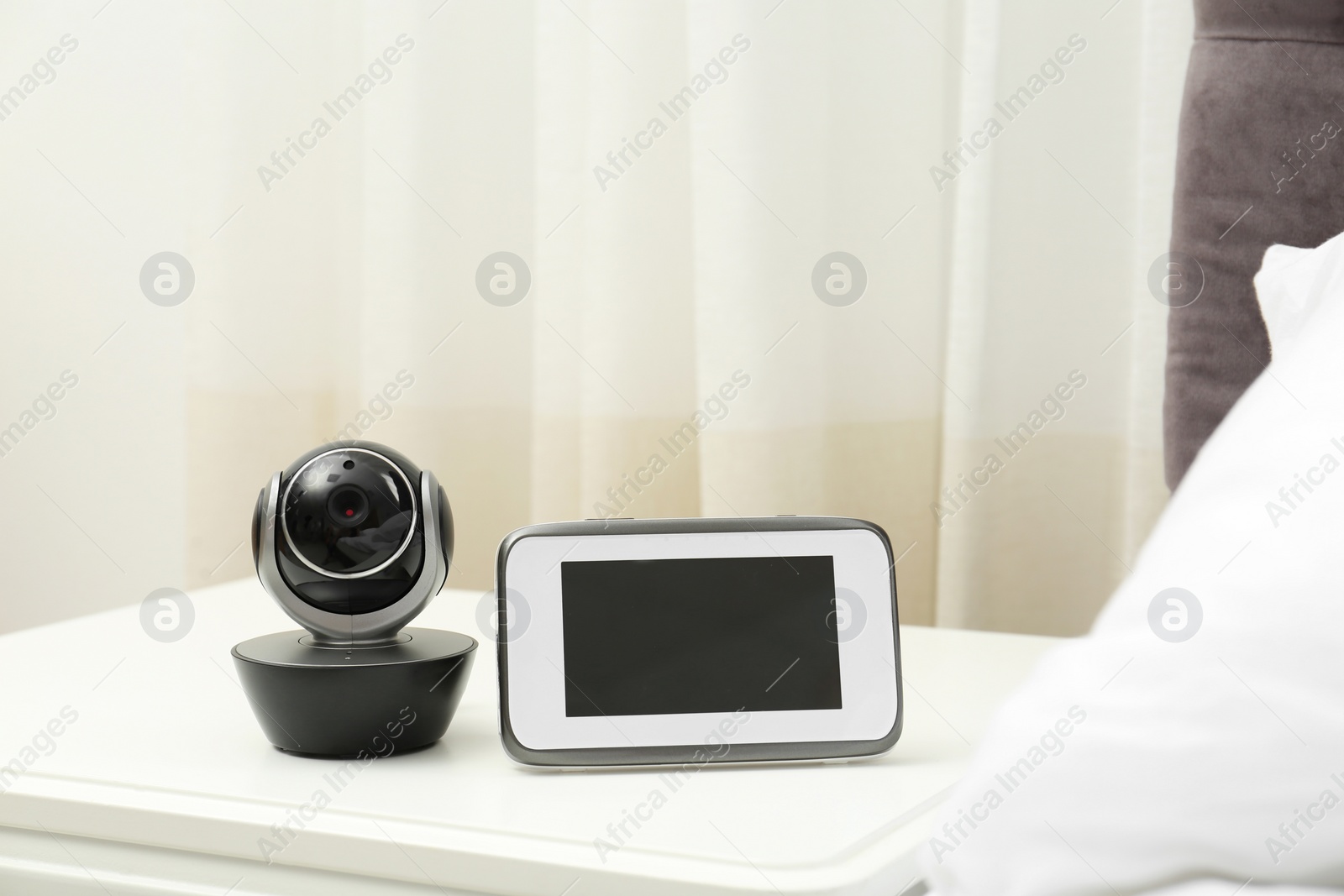 Photo of Baby monitor with camera on table in bedroom. Video nanny