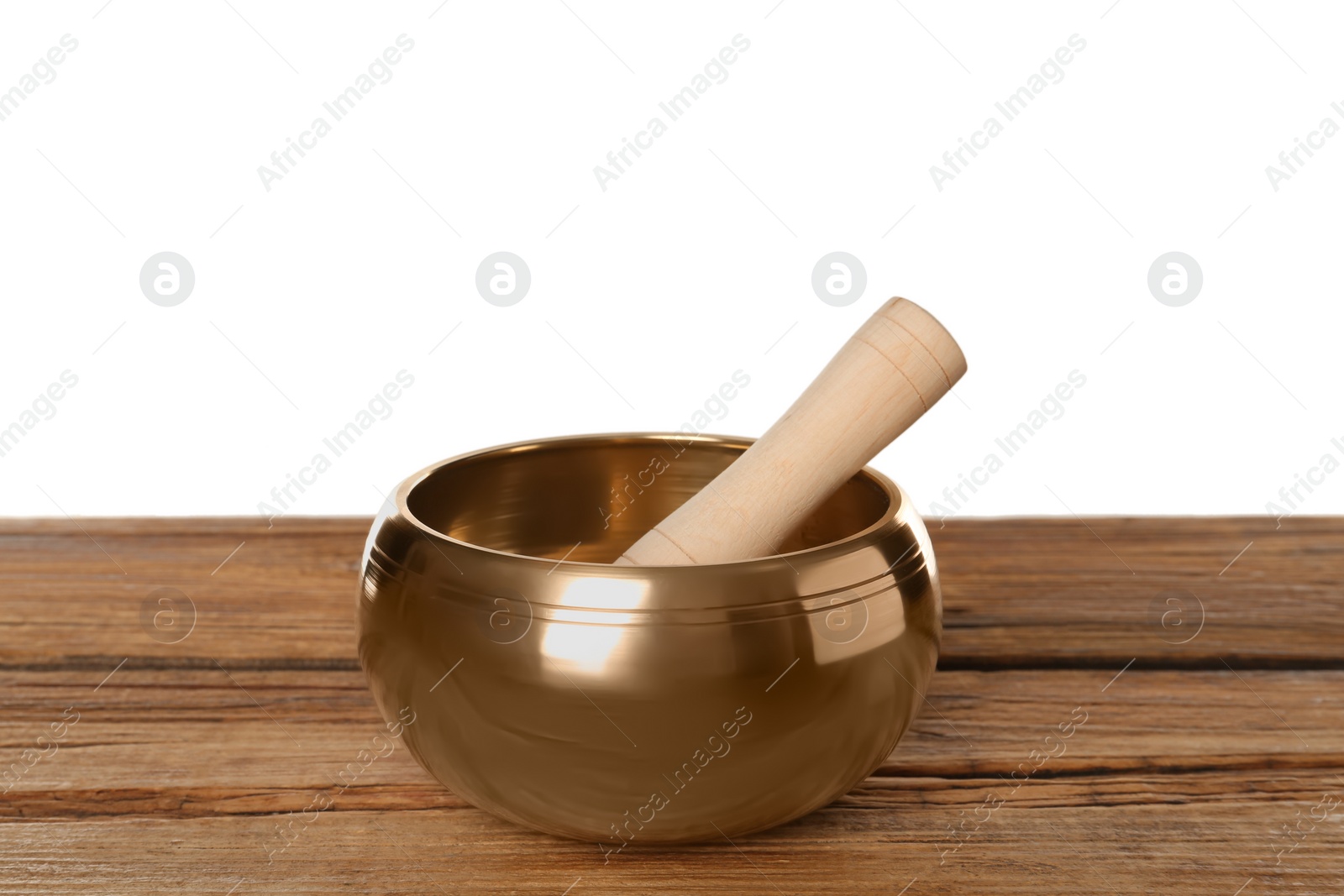 Photo of Golden singing bowl and mallet on wooden table against white background