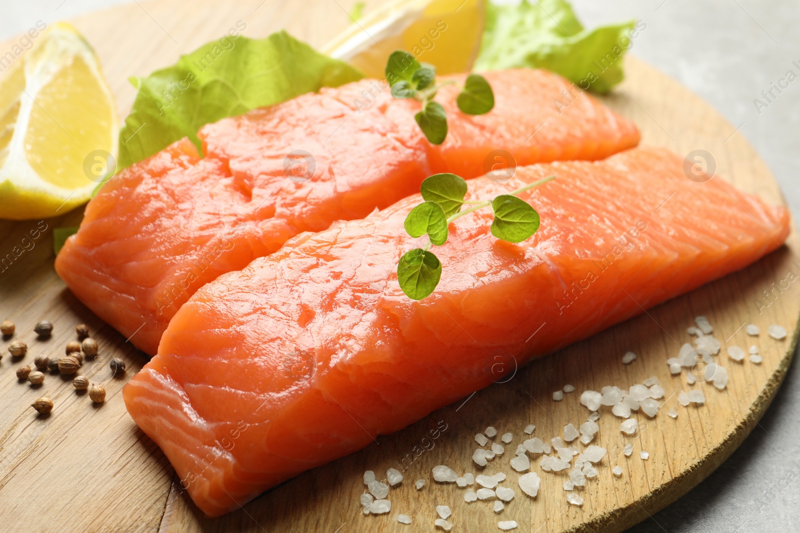 Photo of Fresh raw salmon and ingredients for marinade on wooden board, closeup