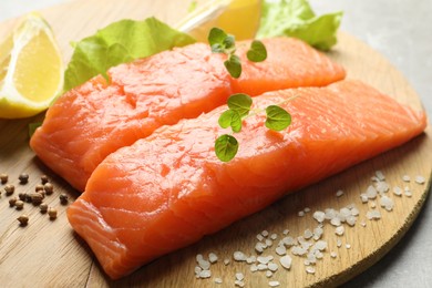 Photo of Fresh raw salmon and ingredients for marinade on wooden board, closeup