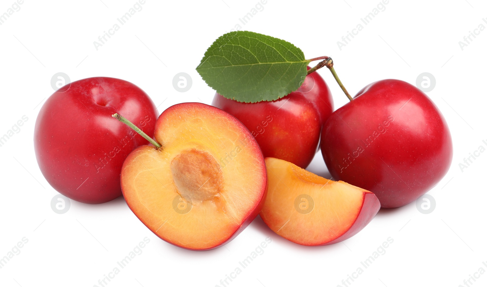 Photo of Cut and whole cherry plums with leaf on white background