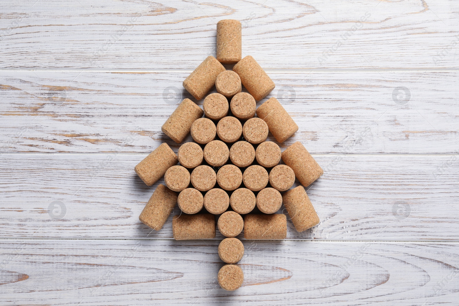 Photo of Christmas tree made of wine corks on white wooden table, top view