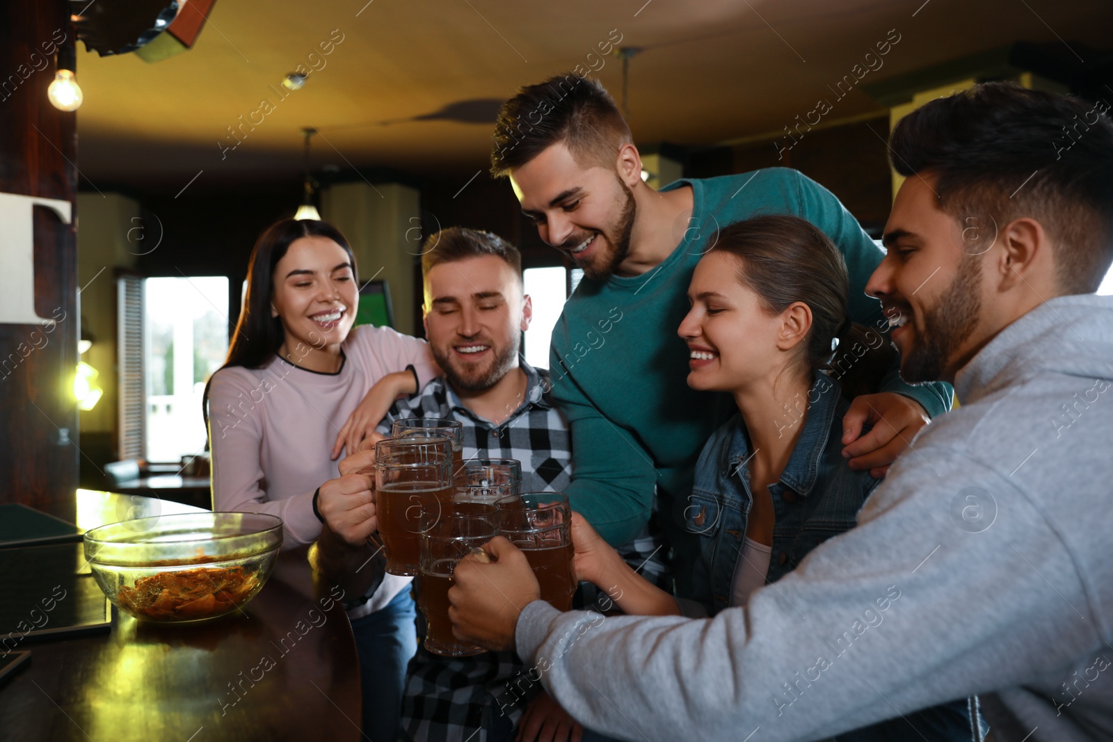 Photo of Group of friends celebrating victory of favorite football team in sport bar