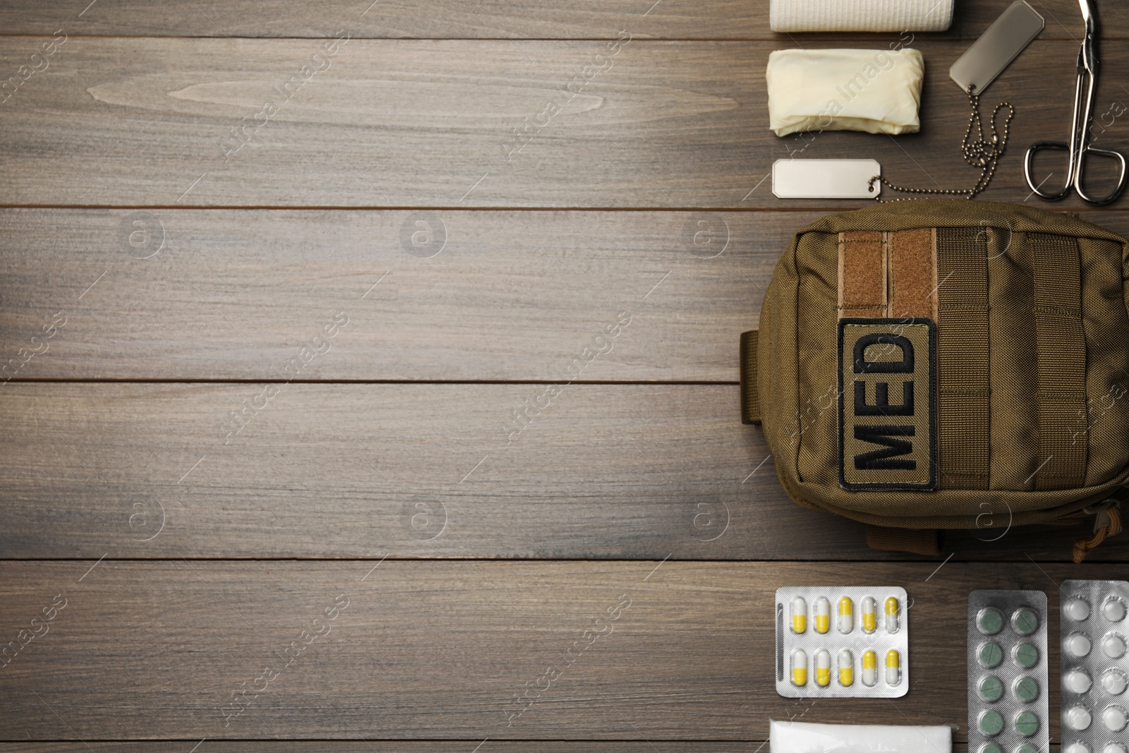 Photo of Military first aid kit on wooden table, flat lay. Space for text