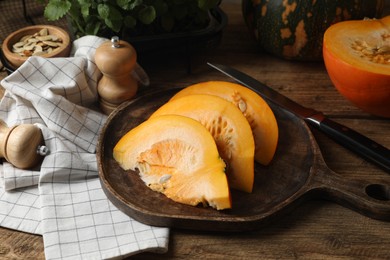 Photo of Cut fresh ripe pumpkin on wooden table