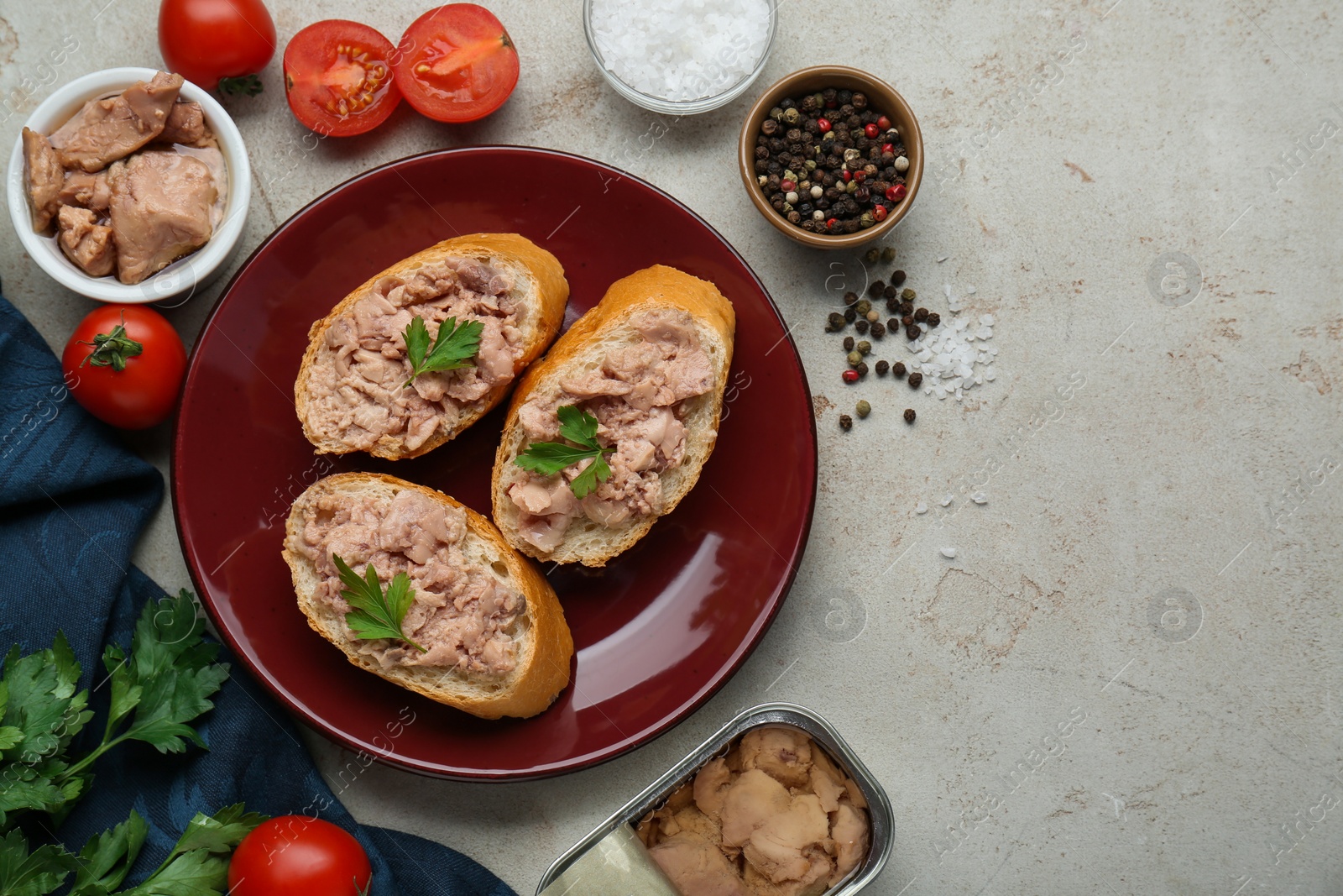 Photo of Tasty sandwiches with cod liver and different products on light grey table, flat lay. Space for text