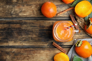 Photo of Tasty persimmon smoothie and fresh fruits on wooden table, flat lay. Space for text