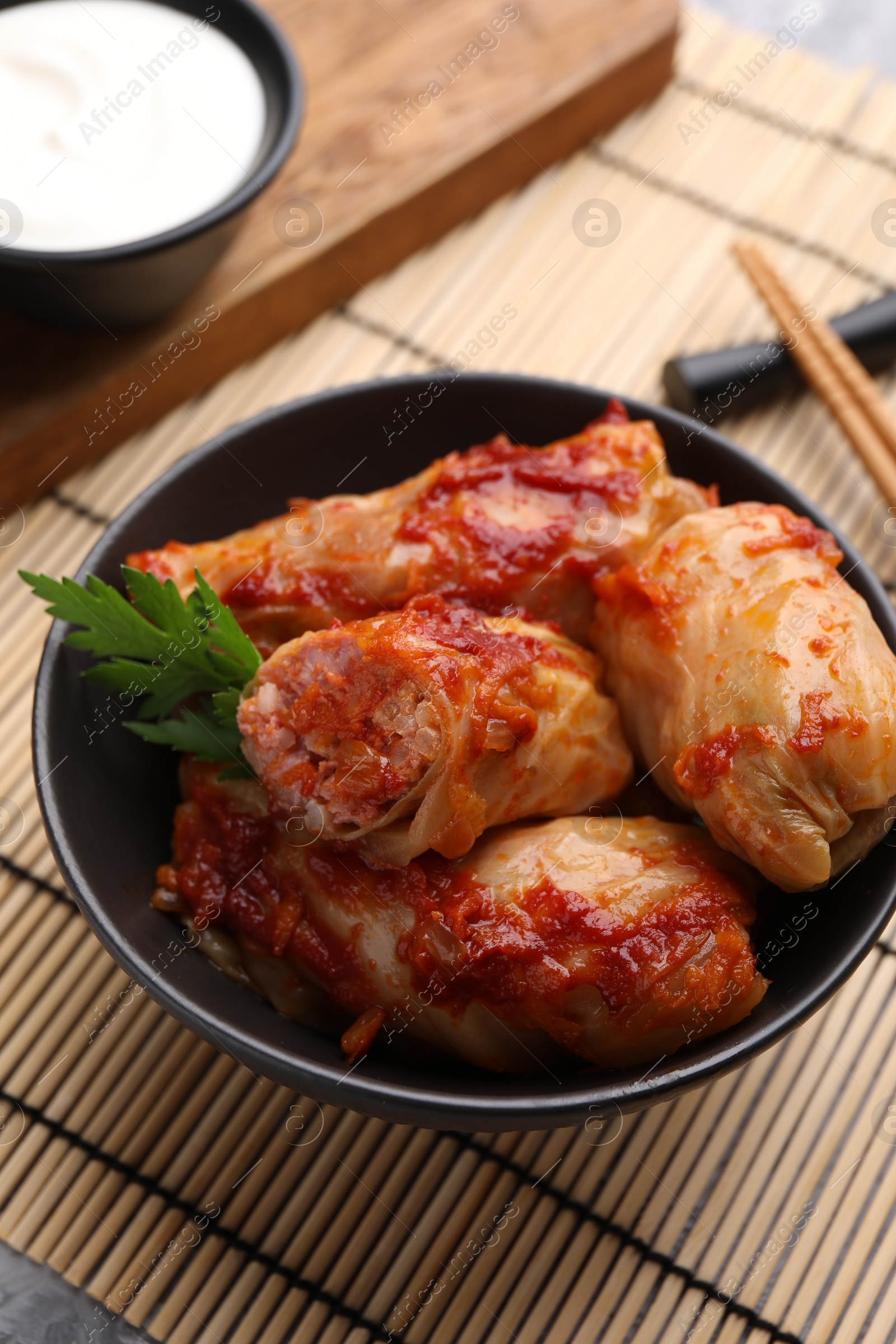 Photo of Delicious stuffed cabbage rolls cooked with homemade tomato sauce on table, closeup