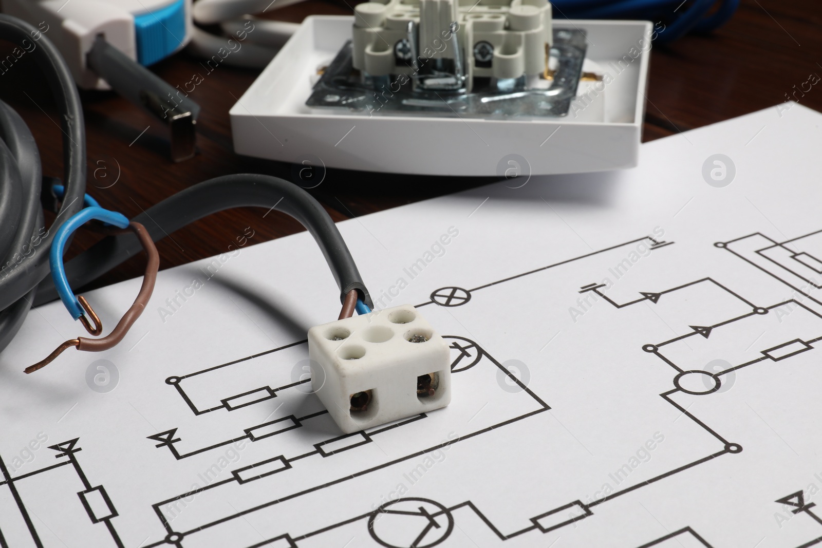 Photo of Wiring diagram, wires and disassembled light switch on wooden table, closeup