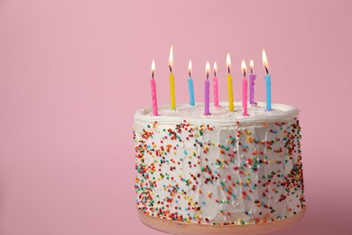 Tasty Birthday cake with burning candles on pink background, space for text