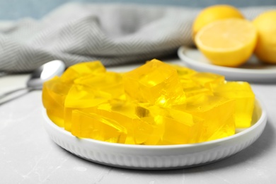 Plate with delicious lemon jelly on table, closeup