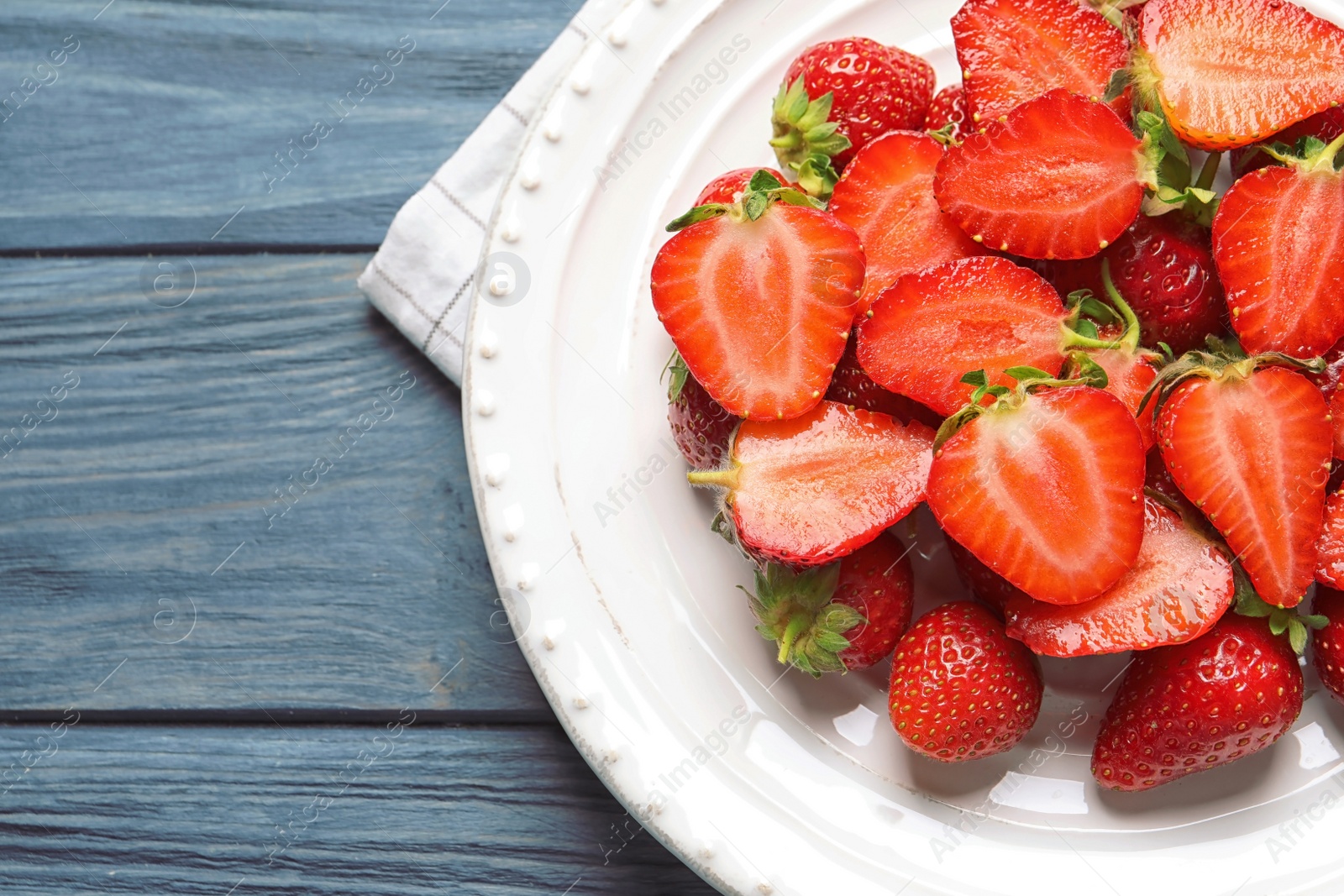 Photo of Plate with ripe strawberries on wooden background, top view