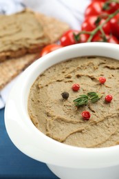 Photo of Tasty liver pate with pepper and herb in bowl on table, closeup