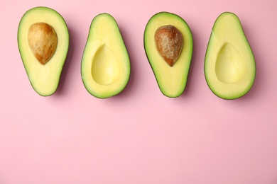 Photo of Cut fresh ripe avocados on pink background, flat lay with space for text