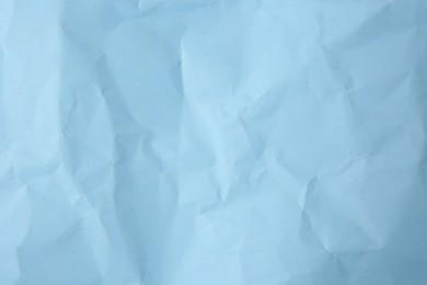 Sheet of crumpled light blue paper as background, top view