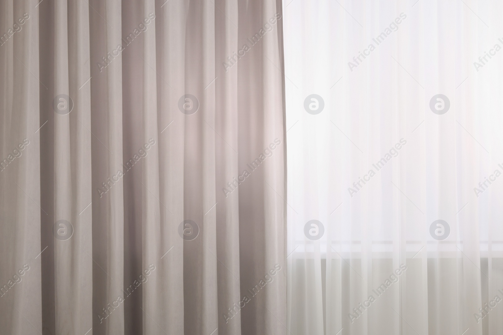 Photo of Light grey window curtains and white tulle indoors, closeup