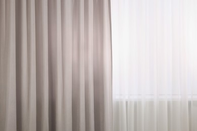 Photo of Light grey window curtains and white tulle indoors, closeup