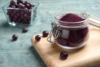 Jar with acai powder on wooden table