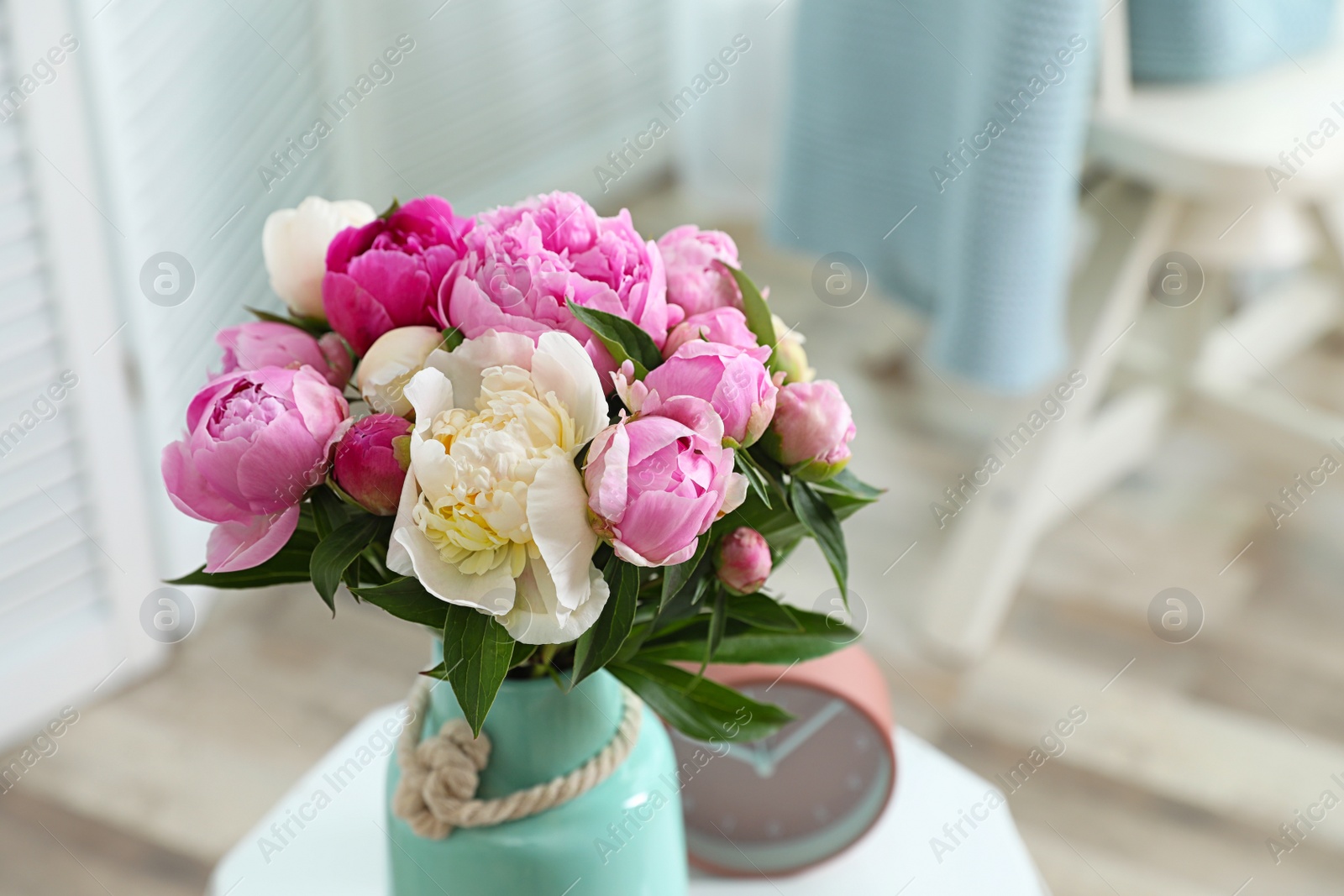 Photo of Vase with bouquet of beautiful peonies on table in room. Space for text