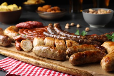 Set of different tasty snacks on wooden board, closeup view