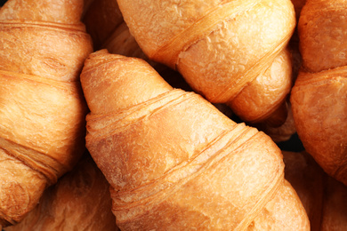 Tasty fresh croissants as background, top view