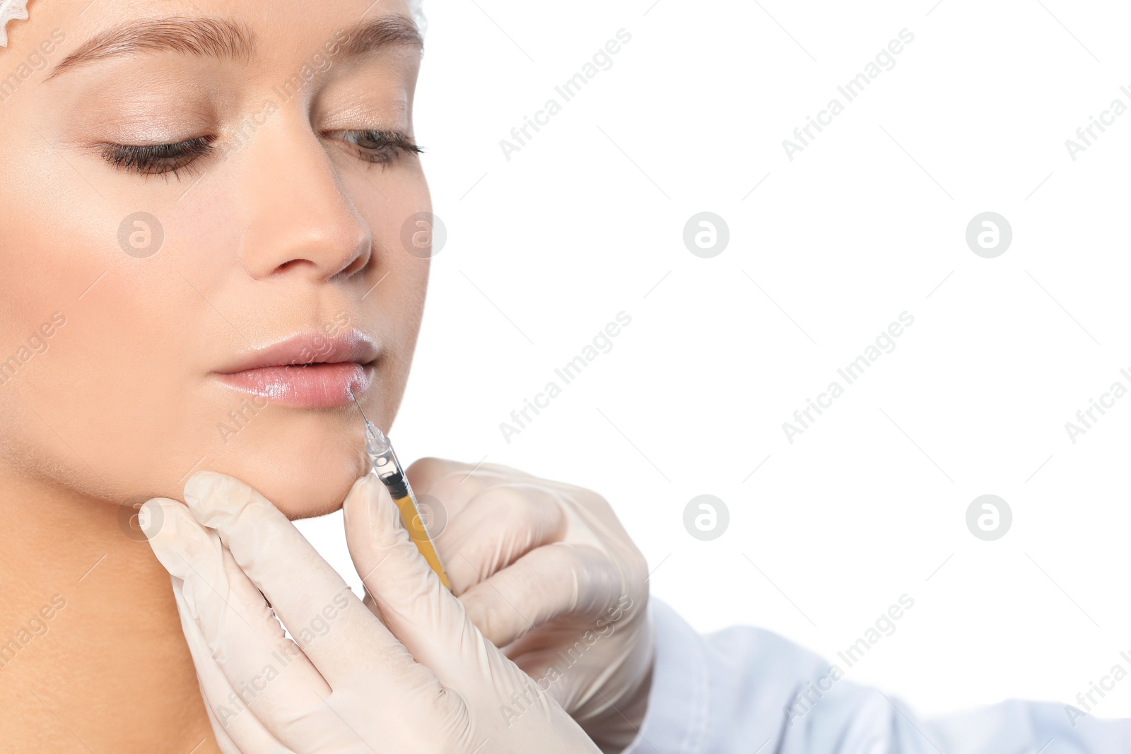 Photo of Young woman getting lips injection on white background, closeup. Cosmetic surgery