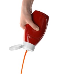 Photo of Woman pouring tasty ketchup from bottle on white background, closeup