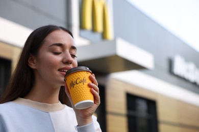 Photo of Lviv, Ukraine - September 26, 2023: Woman with hot McDonald's drink outdoors, space for text