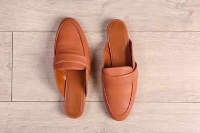 Pair of female shoes on wooden background, top view