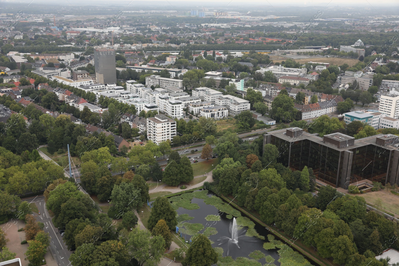 Photo of View of beautiful city with buildings, trees and fountain