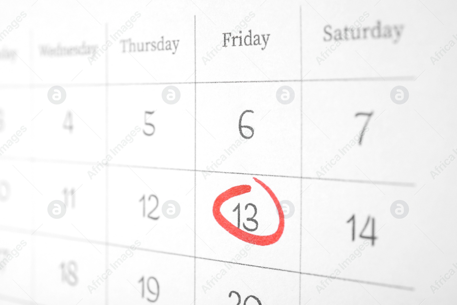 Photo of Calendar page with marked Friday 13, closeup. Bad luck superstition