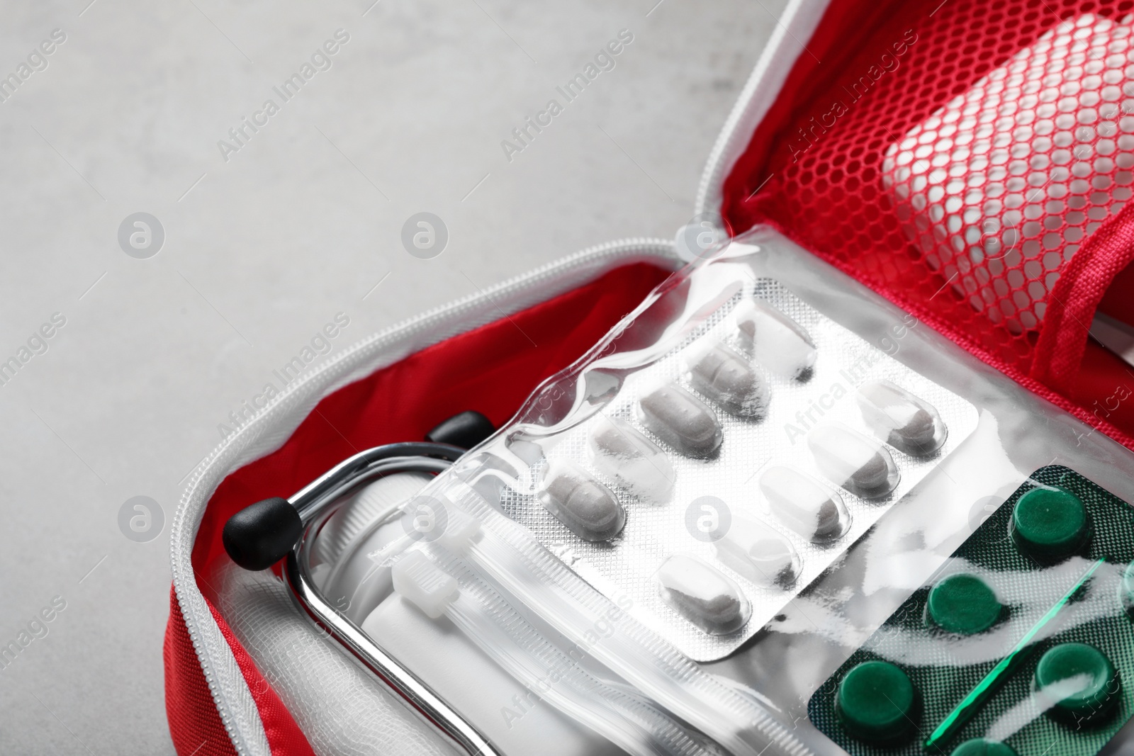 Photo of First aid kit on gray table, closeup