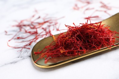 Photo of Dried saffron on white marble table, closeup