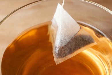 Teabag in cup with hot fresh drink, closeup