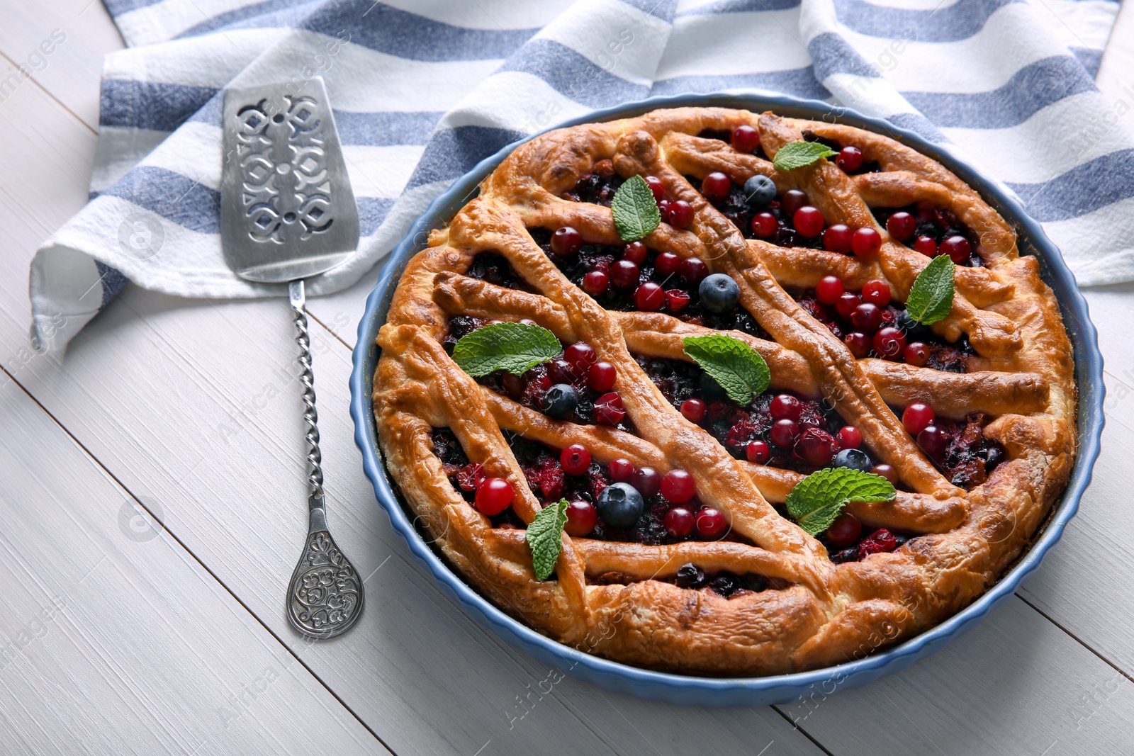 Photo of Delicious currant pie and fresh berries on white wooden table