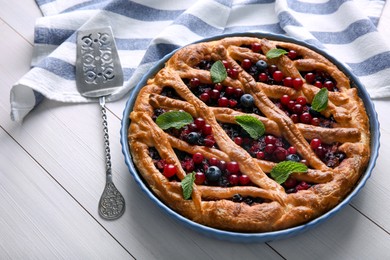 Photo of Delicious currant pie and fresh berries on white wooden table