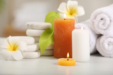 Composition with different spa products and plumeria flowers on white table, closeup