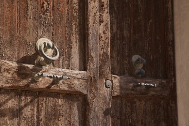 Photo of Old wooden door outdoors on sunny day, closeup