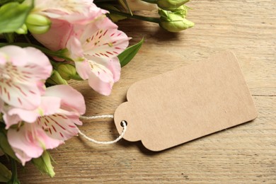 Photo of Happy Mother's Day. Beautiful flowers with blank card on wooden table, closeup