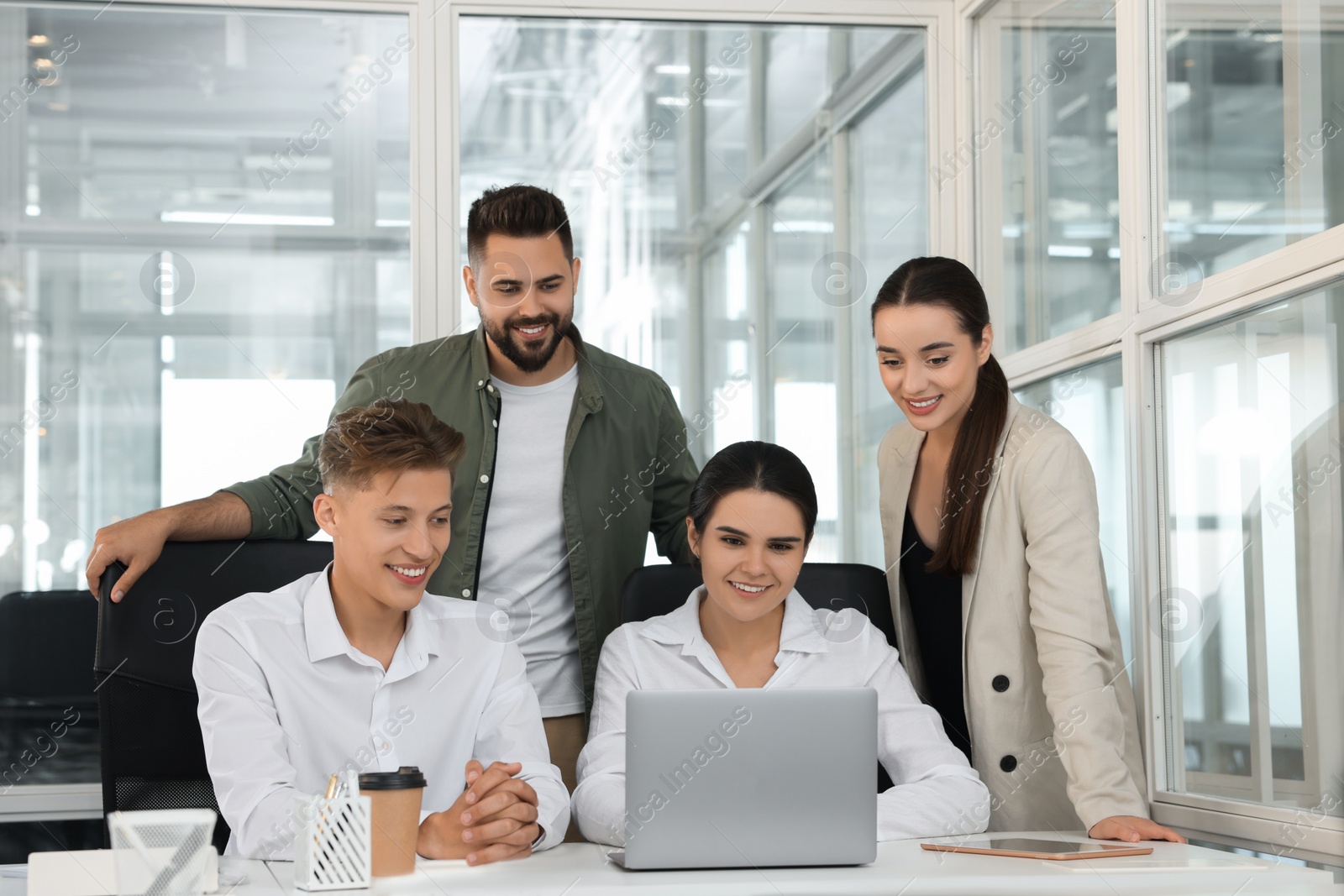 Photo of Colleagues working together in open plan office