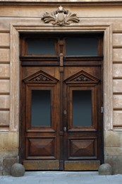 Entrance of house with beautiful wooden door, elegant molding and transom window