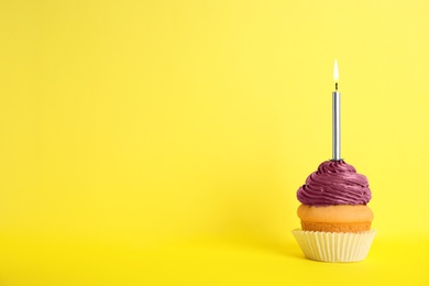 Birthday cupcake with candle on yellow background, space for text