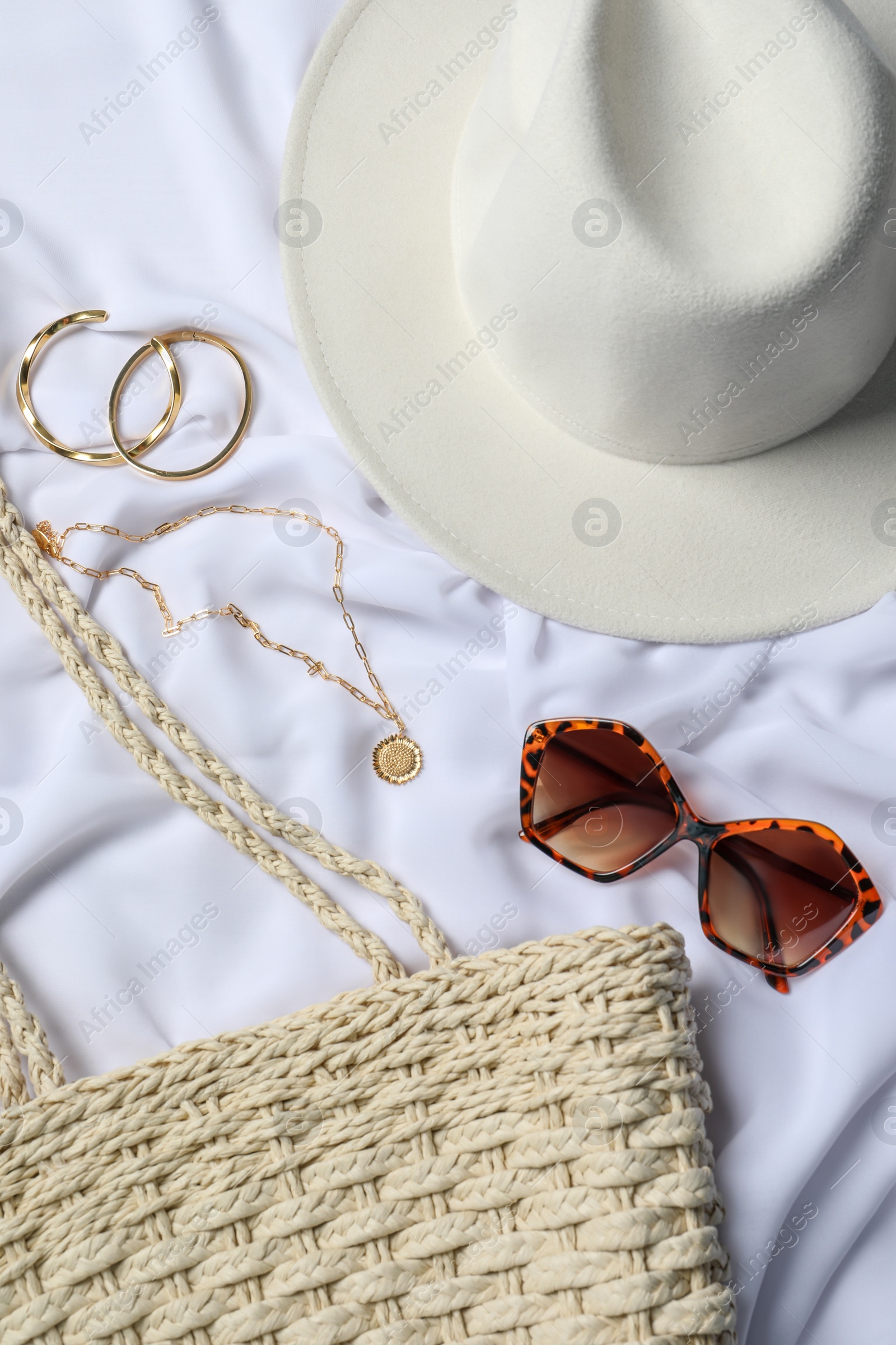 Photo of Flat lay composition with elegant bijouterie and accessories on white cloth