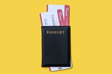 Photo of Top view of passport with tickets on yellow background. Travel agency concept