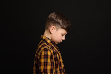 Photo of Upset boy on black background. Children's bullying