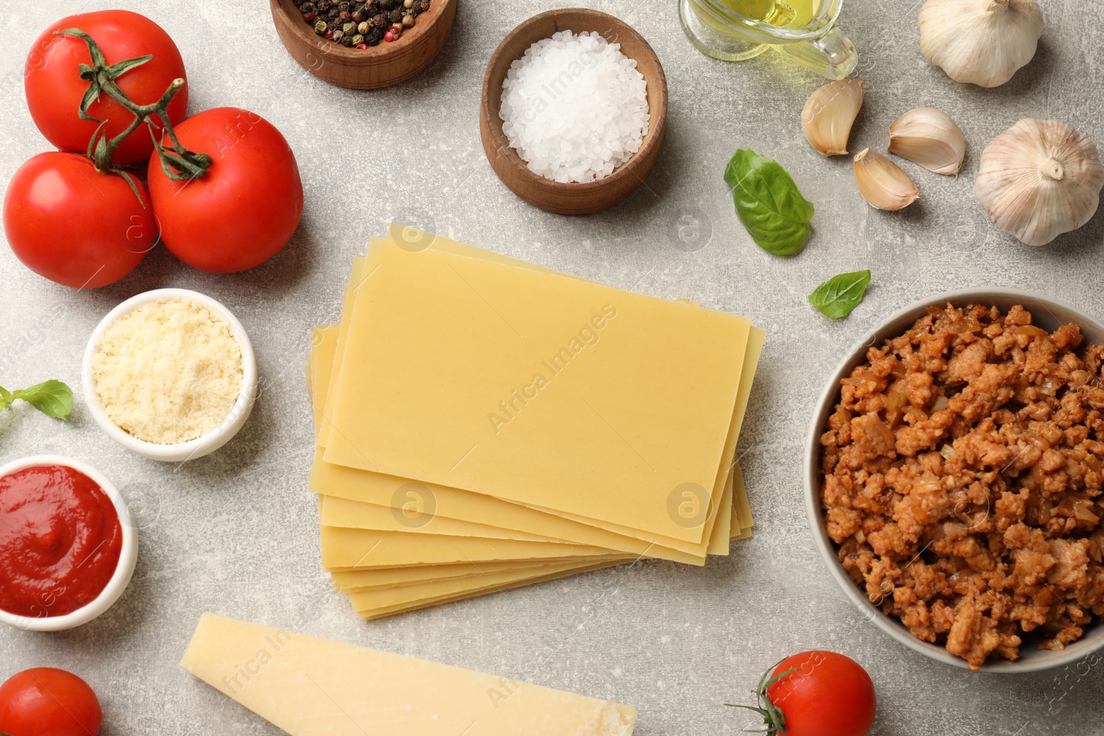 Photo of Flat lay composition with products for cooking lasagna on grey textured table