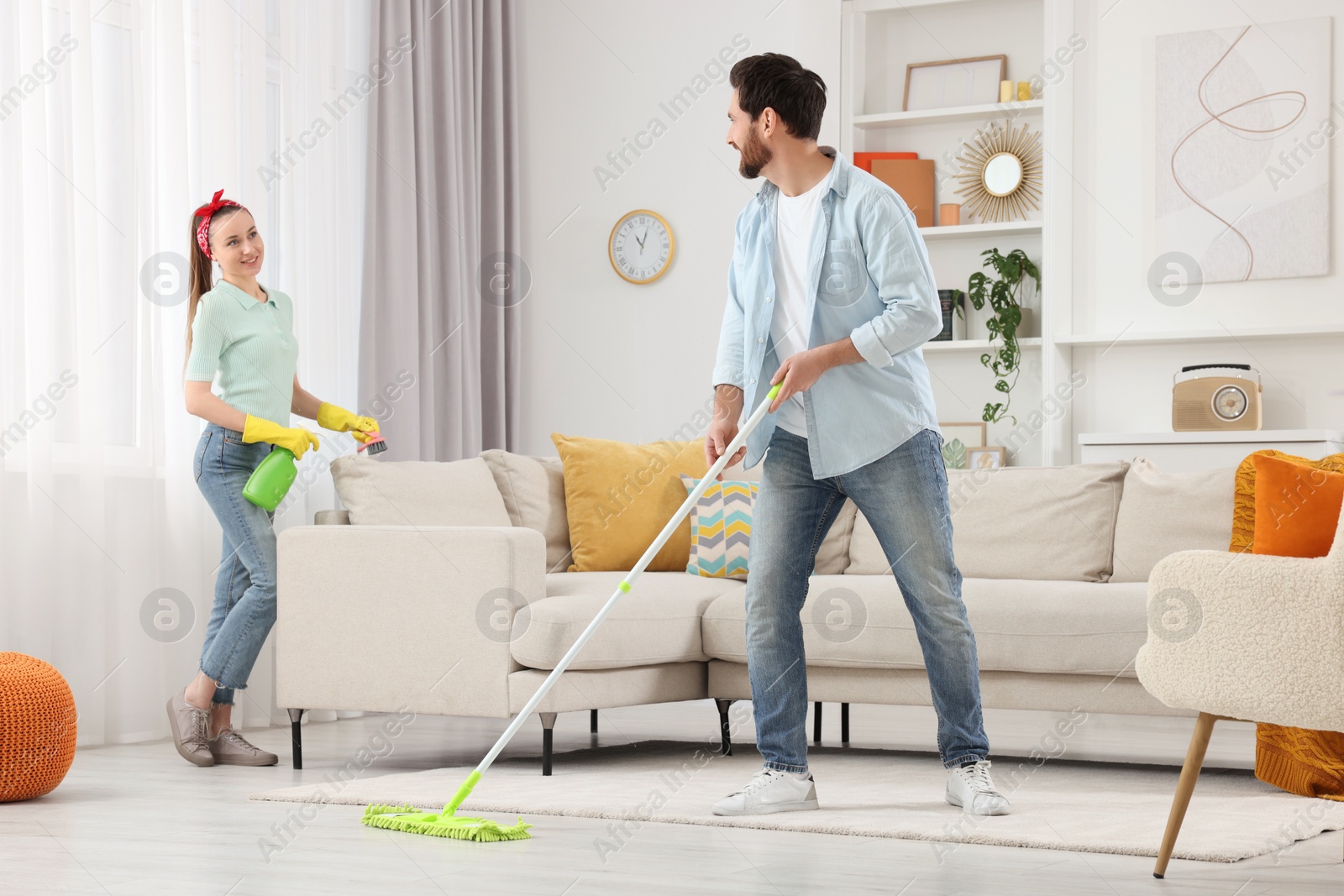 Photo of Spring cleaning. Couple tidying up living room together