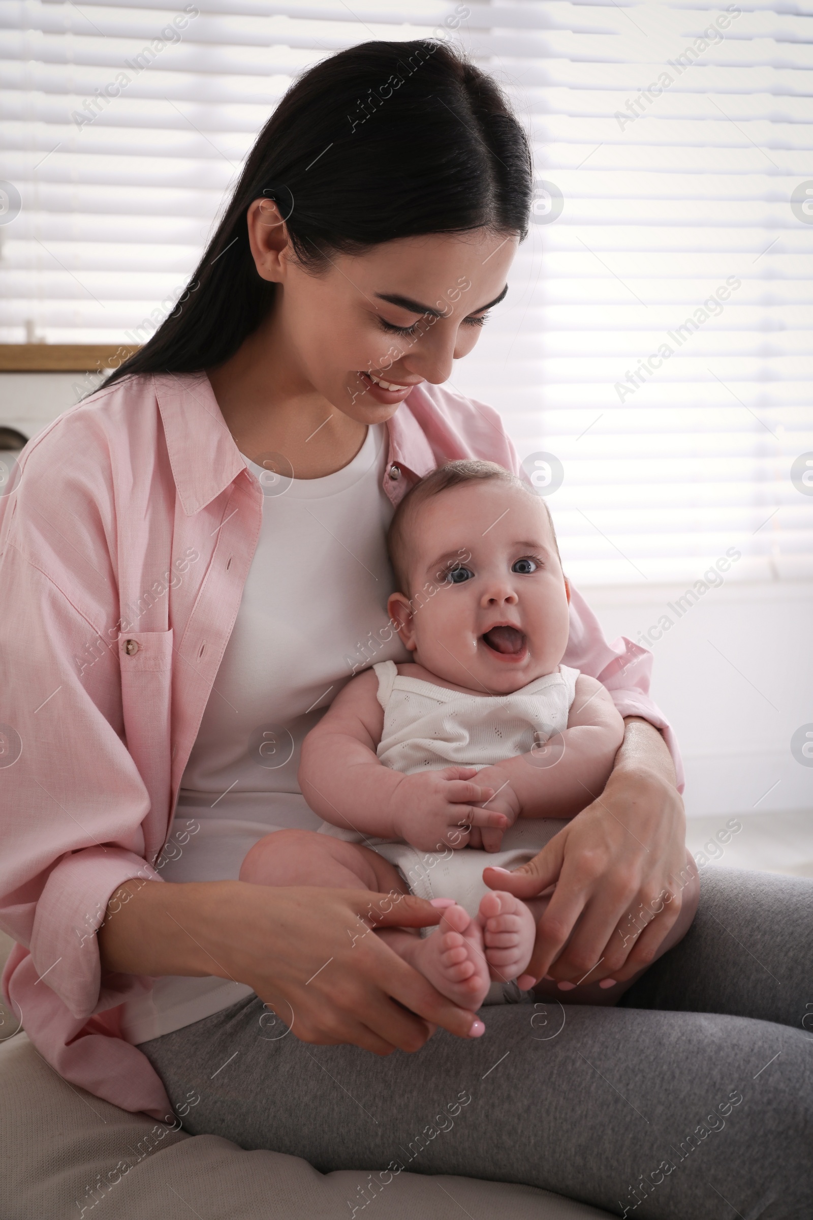 Photo of Young mother with her little baby at home