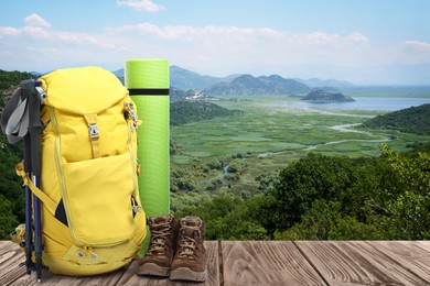 Camping equipment for tourist on wooden surface and beautiful view of mountain landscape